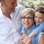 Famiglia con babbo mamma e bambino aggrappato alle spalle della mamma